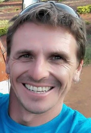 Alex Porras, Andaspain guide, smiles warmly in a close-up selfie wearing a blue t-shirt and sunglasses pushed up on his head.